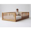 Dieťa na orechovej montessori posteli Monty Bed
